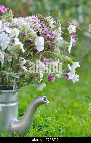bouquet of wild flowers in old teapot in garden Stock Photo