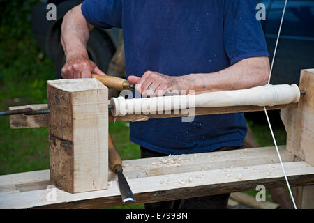 Close up of man person traditional wood turning turner working using a pole hand lathe England UK United Kingdom GB Great Britain Stock Photo