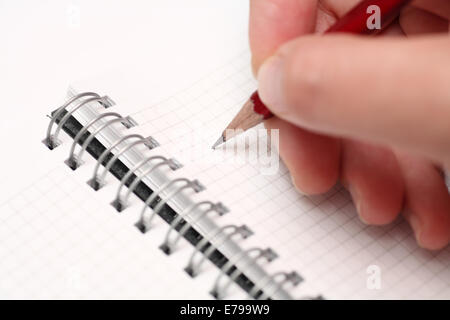 Writing on notepad with pencil. Close-up. Stock Photo