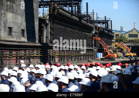 Anshan, China's Liaoning Province. 10th Sep, 2014. Engineering vehicles dismantle pollutive coke furnaces at Anshan Iron & Steel Group in Anshan, northeast China's Liaoning Province, Sept. 10, 2014. Anshan Iron & Steel Group, China's second-largest steel maker, tore down six fuel-inefficient coke furnaces on Wednesday in response to the 'blue sky project', an emission-reduction campaign in Liaoning Province aimed at improving air quality. © Yang Qing/Xinhua/Alamy Live News Stock Photo