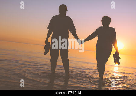 Happy senior couple silhouettes on the beach