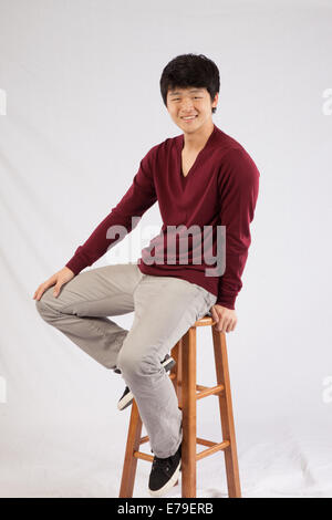 Asian man sitting and smiling at the camera Stock Photo