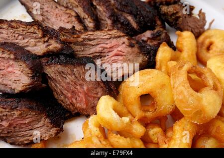 Juicy Flank steak with fries onion rings Stock Photo