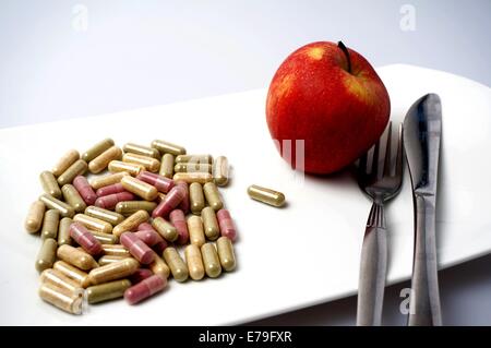 many Medicine capsule vs one healthy apple Stock Photo