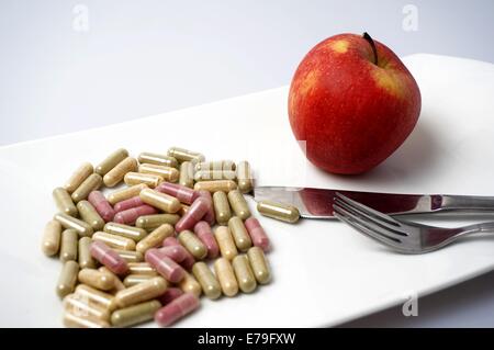 many Medicine capsule vs one healthy apple Stock Photo