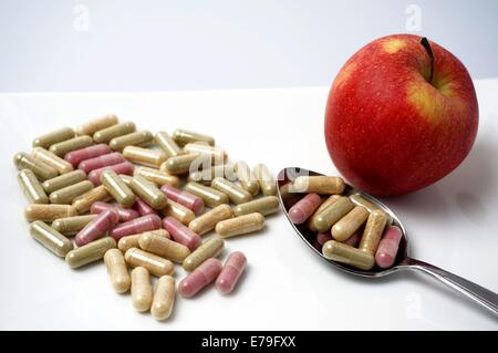 many Medicine capsule vs one healthy apple Stock Photo