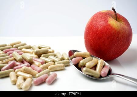 many Medicine capsule vs one healthy apple Stock Photo