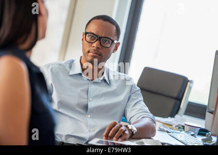 A man and woman talking in an office. Stock Photo