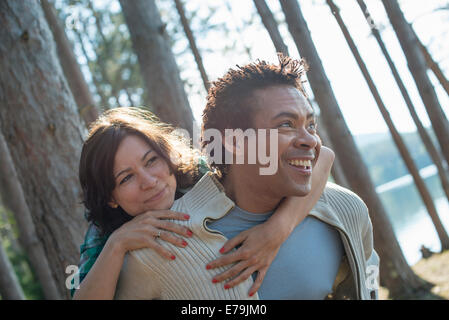 A couple close together, hugging in the shade of trees. Stock Photo