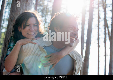 A couple close together, hugging in the shade of trees. Stock Photo