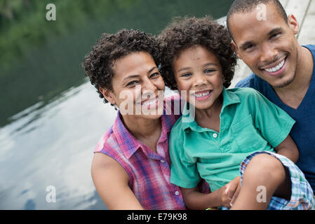 A family, parents and a young boy, by a lake in summer. Stock Photo