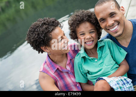 A family, parents and a young boy, by a lake in summer. Stock Photo