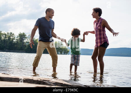 A family, parents and son by a lake in summer. Stock Photo