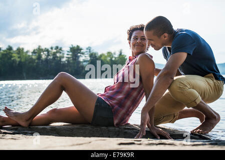 A couple close together by a lake in summer. Stock Photo