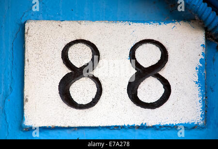 street digits number closeup on blue wall background Stock Photo