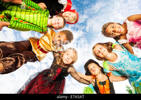 Many kids, Halloween costumes look down in circle Stock Photo