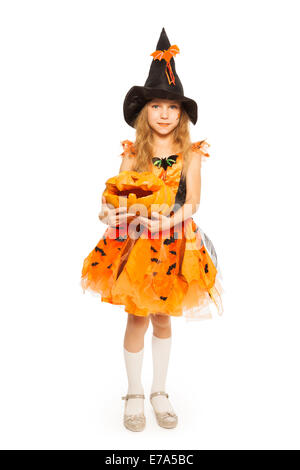 Girl in witch dress hold carved Halloween pumpkin Stock Photo
