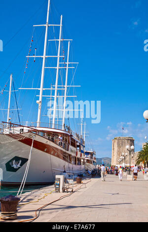 Croatia, Trogir: tourists on the sea promenade with touristic cruise ships moored and the view of the tower of Kamerlengo castle Stock Photo