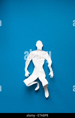 Directly above shot of crumpled paper man lying on blue background Stock Photo