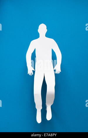 Directly above shot of paper man lying on blue background Stock Photo