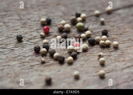 Variety of peppercorns on wooden table Stock Photo