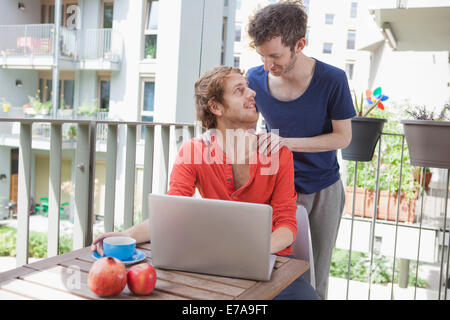 Affectionate gay couple looking at each other at porch Stock Photo