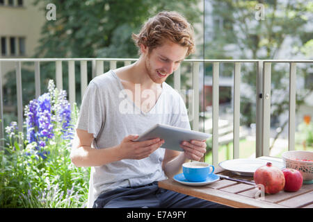 Smiling man using digital tablet at porch Stock Photo