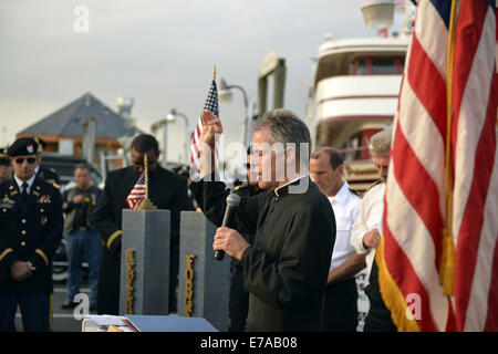 Freeport, New York, USA. 10th Sep, 2014. A pastor gives a blessing at a dockside remembrance ceremony in honor of victims of the terrorist attacks of September 11 2001, at the boat Miss Freeport V, on Freeport's Nautical Mile. Further ceremonies were held on board the vessel, which sailed from the Woodcleft Canal on the South Shore of Long Island, on the eve of the 13th Anniversary of the 9/11 attacks. © Ann Parry/ZUMA Wire/Alamy Live News Stock Photo