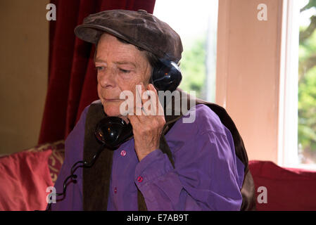 Woman with old fashioned telephone receiver and cigarette, London, UK Stock Photo