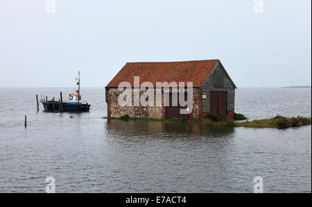 Thornham, Norfolk, UK. 11th Sept 2014. An exceptionally high tide floods the harbour, Staithe Road and the saltmarshes at Thornham on the North Norfolk Coast leaving Coal Barn high and dry. Credit:  Stuart Aylmer/Alamy Live News Stock Photo