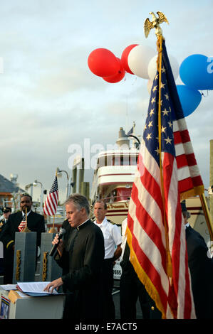 Freeport, New York, USA. 10th Sept. 2014. A pastor gives a blessing at a dockside remembrance ceremony in honor of victims of the terrorist attacks of September 11 2001, at the boat Miss Freeport V, on Freeport's Nautical Mile. Further ceremonies were held on board the vessel, which sailed from the Woodcleft Canal on the South Shore of Long Island, on the eve of the 13th Anniversary of the 9/11 attacks. Credit:  Ann E Parry/Alamy Live News Stock Photo