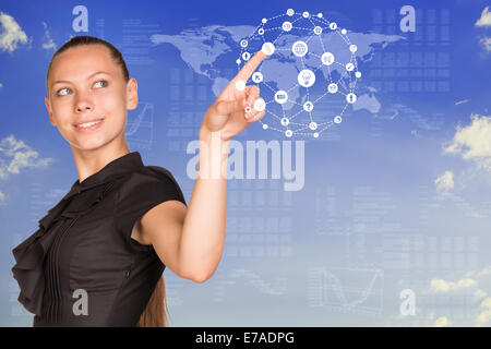 Beautiful businesswoman in dress presses finger virtual sphere of icons Stock Photo