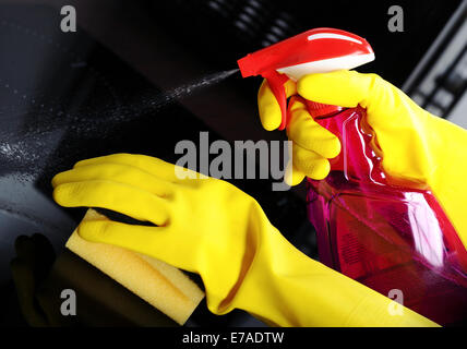 Woman with sponge and rubber gloves cleaning kitchen Stock Photo