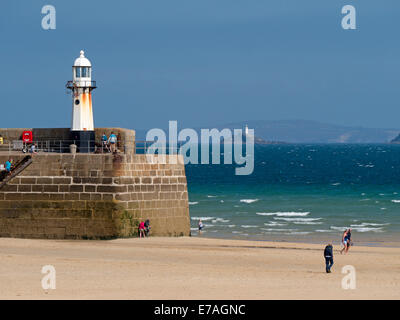 St. Ives harbour beach and pier with Godrevy lighthouse in the distance. Stock Photo