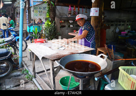 Old women cooking deep-fried doughstick or chinese donut or chinese bread for sale Stock Photo