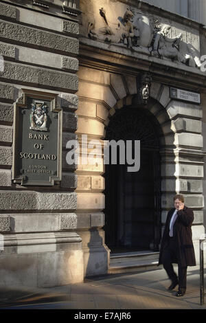 A man in business dress walks through the Bishopsgate in London's business district and passes a sign of the Bank of Scotland. Picture taken in March 2005. Stock Photo