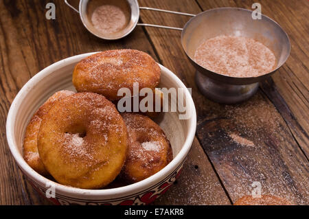 Donuts flavored with cinnamon, nutmeg and powdered sugar, on a wooden  table Stock Photo
