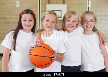 Female School Sports Team In Gym With Basketball Stock Photo