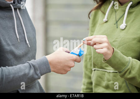 Close Up Of Teenager Boy Offering Girl Cigarette Stock Photo