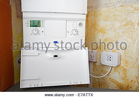 Newly installed Gas Combi boiler with wireless sensor for room thermostat Stock Photo