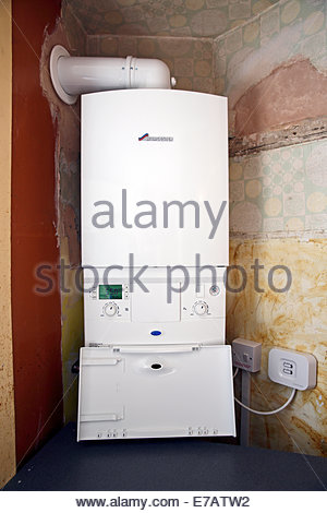 Newly installed gas combi boiler with wireless sensor for room thermostat Stock Photo