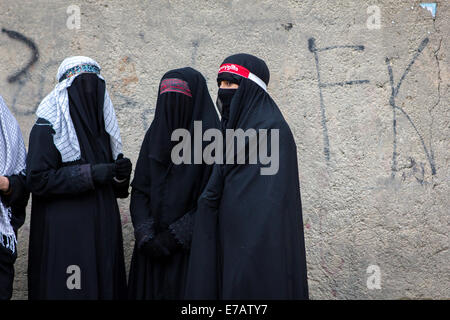 Young Shiite Muslim women, wearing traditional black chadors, are mourning during the Day of Ashura in Bijar, Iran. Stock Photo