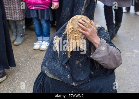 A Shiite Muslim woman, wearing a black chador covered with mud, prays on the streets of Bijar, Iran, during the Day of Ashura. Stock Photo