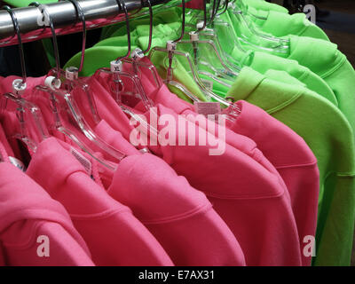 Detail of shirts or clothing hanging on racks hangers Stock Photo