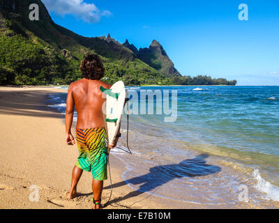 Surfer at Tunnels Beach on Kauai looks at Mt. Makana, called Bali Hai Stock Photo