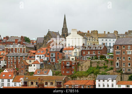 Crowded red brick houses and apartment blocks on steep hillside at English coastal town of Whitby, Yorkshire England Stock Photo