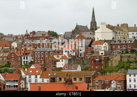 Crowded red brick houses and apartment blocks on steep hillside at English coastal town of Whitby, Yorkshire England Stock Photo