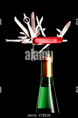 Swiss Army knife, with all parts unfolded, corkscrew in a white wine bottle Stock Photo