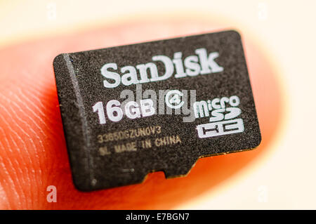 A SanDisk 16GB MicroSD SDHC card for use in Smartphones on a fingertip Stock Photo