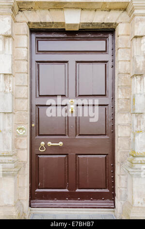 Large wooden front door to a house with brass door furniture Stock Photo